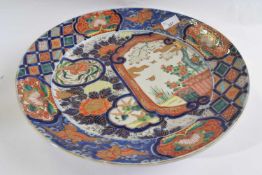 A large Japanese porcelain charger Meiji period with design of a panel with flowering plants amongst