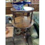 19th Century circular two tiered dumb waiter raised on a turned column and tripod base with casters,