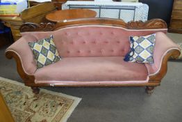 A Victorian mahogany framed and pink upholstered sofa with decorative carved wooden back, 100cm