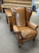A 20th Century brown leather upholstered wing back armchair, 107cm high