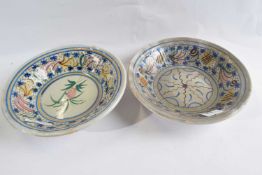 A pair of delft style bowls with polychrome floral decoration, 23cm diameter