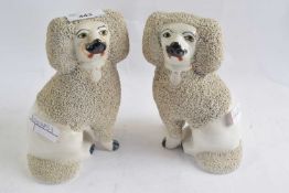 A pair of Staffordshire porcelain poodles with black and yellow faces