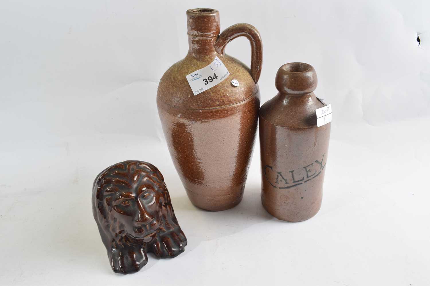 A ginger beer bottle Bourne Denby marked Caley together with a stoneware flask and a treacle