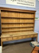 A late 19th or early 20th Century pine dresser of huge proportions, the shelved back over a base