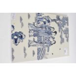 A Chinese porcelain rectangular panel painted in blue with Chinese ladies in a garden setting,