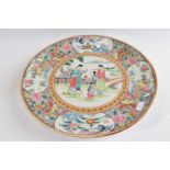 A Chinese porcelain dish with polychrome design of figures in a garden setting, the borders with