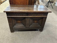 A 17th Century oak coffer reputedly of Flemish origin with two plank lid over a base with two