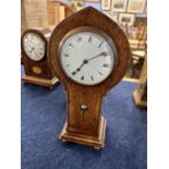 A Art Nouveau shaped oak mantel clock with key