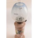 A 19th Century oil lamp, the glass body painted with flowers with glass light blue shade and a