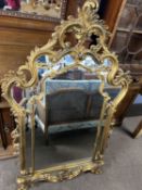 An 18th Century style gilt wood wall mirror with elaborate scrolling and foliate mounted frame,
