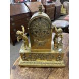 A late 19th Century lacquered brass cased mantel clock of architectural form with two cherub