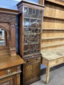 A 19th Century mahogany two piece bookcase cabinet of narrow form, the top section with single