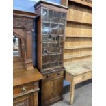 A 19th Century mahogany two piece bookcase cabinet of narrow form, the top section with single