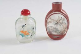 Small plastic bag containing two snuff bottles, glass with painted decoration, both with birds and