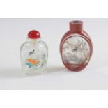 Small plastic bag containing two snuff bottles, glass with painted decoration, both with birds and