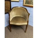 An Edwardian mushroom upholstered bow back chair raised on tapering legs with spade feet