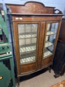 Edwardian mahogany and inlaid china display cabinet of bow front form with two lead glazed doors,