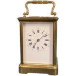 A large early 20th Century brass carriage clock, white enamel dial with Roman numerals,