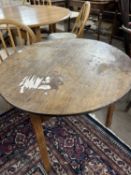 A 19th Century oak and pine cricket table with circular top raised on a three footed base, top is