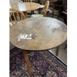 A 19th Century oak and pine cricket table with circular top raised on a three footed base, top is