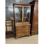 An 18th Century and later combination bookcase chest with two glazed doors over a base with two