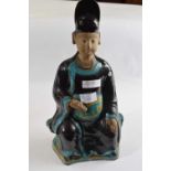 A Chinese pottery terracotta figure of a seated official holding a Ruyi in one hand, 40cm high
