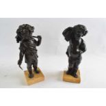 Two bronze figures of putti emblematic of harvest and one other both on rectangular marble bases,