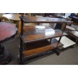 A 20th Century mahogany three tier buffet cabinet raised on turned side supports, 125cm wide