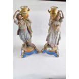 A pair of French bisque porcelain Middle Eastern water carriers on blue circular bases, 40cm high