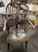 A 19th Century yew and elm Windsor chair with central wheel formed splat and stick back raised on