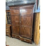 A 19th Century mahogany wardrobe with moulded cornice over two panelled doors and a base drawer