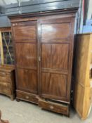 A 19th Century mahogany wardrobe with moulded cornice over two panelled doors and a base drawer