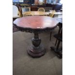 An unusual Chinese red and black lacquered pedestal table with lobed top with pierced freize (partly