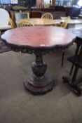 An unusual Chinese red and black lacquered pedestal table with lobed top with pierced freize (partly