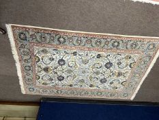 A 20th Century Middle Eastern wool floor rug decorated with central floral panel on a beige