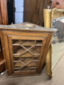 A 19th Century oak corner cabinet with single astragal glazed door opening to a shelved interior,