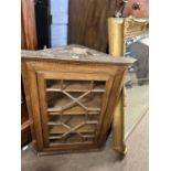 A 19th Century oak corner cabinet with single astragal glazed door opening to a shelved interior,