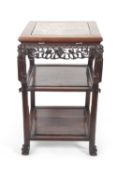 A Chinese hardwood and marble inset three tier occasional table or plant stand with pierced carved