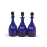 A group of three late 19th/early 20th Century Bristol blue glass decanters with ball stoppers and