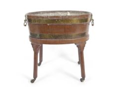 A 19th Century mahogany and brass bound oval wine cooler with metal liner and brass lions head