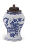 A Chinese porcelain vase of inverted baluster form with blue and white decoration and pierced wooden