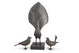 An Indian steel model of a stylised peacock, 45cm high together with two accompanying small model