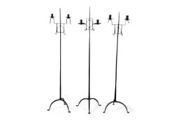 A group of three 18th Century or later wrought iron floor standing adjustable double light candle