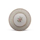 A Swansea plate decorated with a floral design to the centre within a gilt and floral border