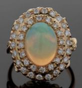 18ct opal and diamond ring, the central oval opal cabochon, approx. 13.1 x 9.8 x 6.1mm, surrounded