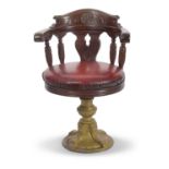 A Late 19th Century hardwood and cast base bow back ships Captains chair with red leather