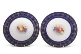 A pair of Royal Worcester plates painted to the centre with fruit and signed by E Townsend within