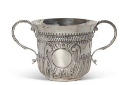 An early 20th Century copy of a George I loving cup, having two beaded scrolled handles, wrythen