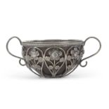 An antique unmarked white metal framed small coconut cup having nine open wire work panels each