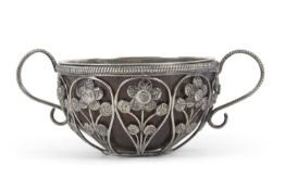 An antique unmarked white metal framed small coconut cup having nine open wire work panels each